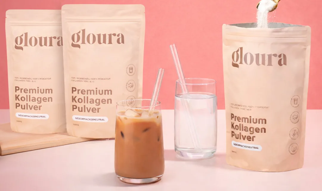 Drei Beutel Gloura Premium Kollagen Pulver, daneben ein Eiskaffee und ein Glas Wasser